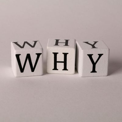 Close-up of lettered dice spelling 'WHY' on a neutral background, ideal for concepts of inquiry or curiosity.