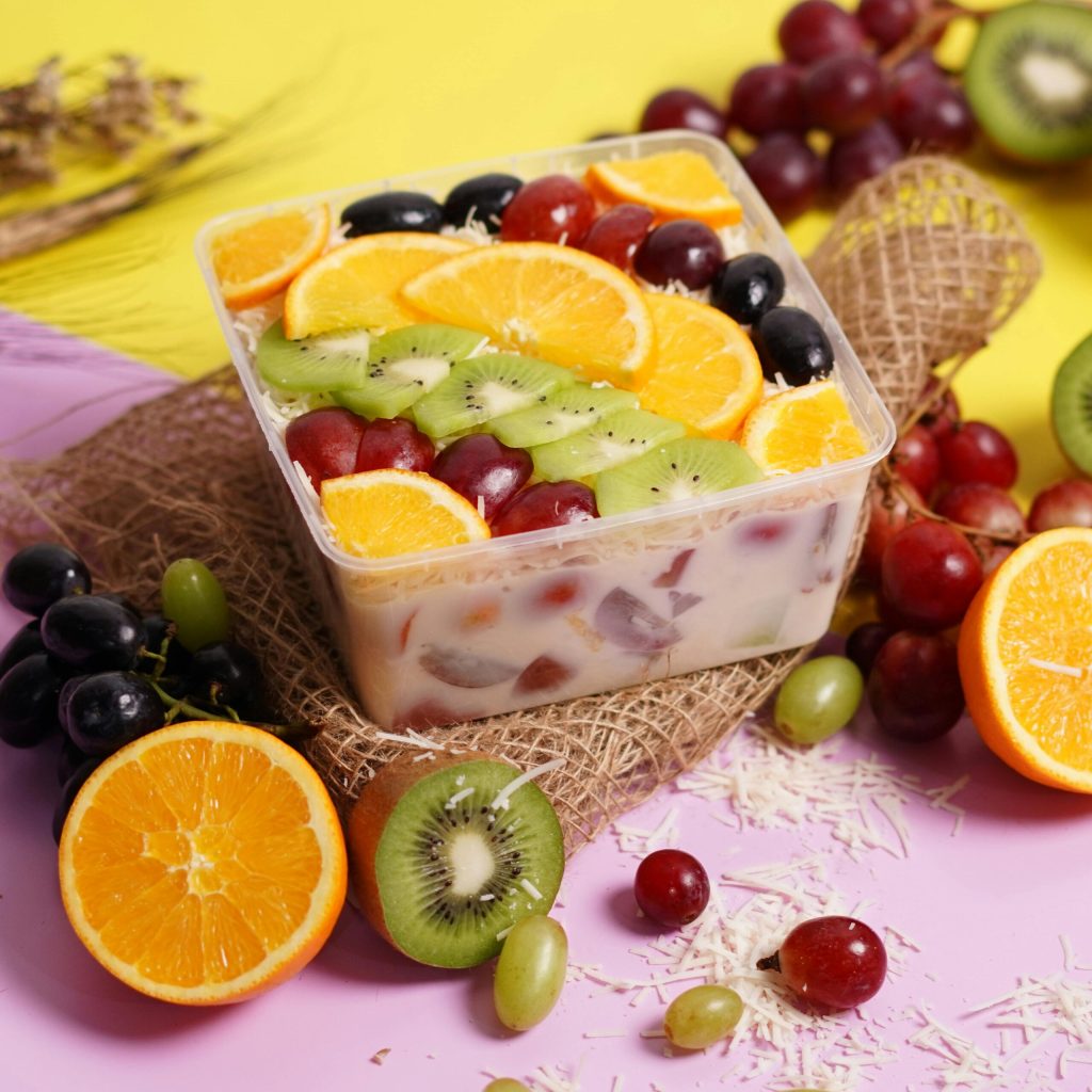 Colorful fruit salad with slices of orange, kiwi, and grapes, perfect for a refreshing dessert.